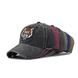 Detail of vintage washed cotton baseball caps featuring embroidered tiger head patches