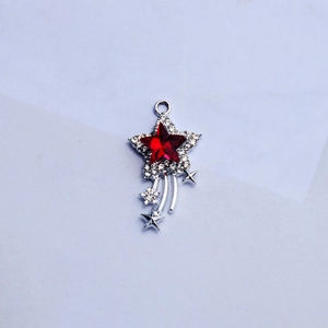 Macro detail of star-shaped pendant with red crystal and silver rhinestone inlay
