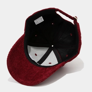 Dettaglio dell'interno del cappellino in velluto con etichetta di lavaggio e cuciture in cotone