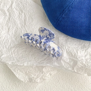 Detail showing the blue and white marble pattern on the glossy acetate hair claw clip
