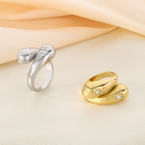 Detail of silver and gold teardrop stainless steel rings with sparkling crystals