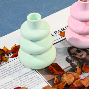 Macro di vasi impilati verde menta e rosa posizionati su una rivista francese di stile