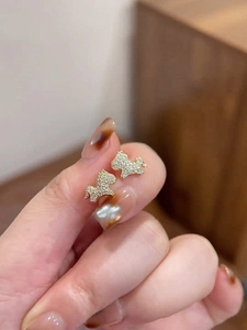 Macro shot of gold-plated puppy stud earrings with sparkling cubic zirconia inlay
