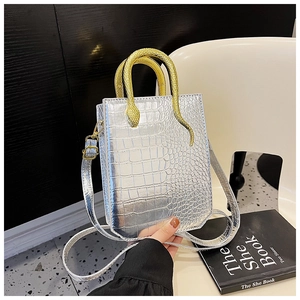 Close-up of silver crocodile embossed handbag featuring a gold snake-shaped metal handle