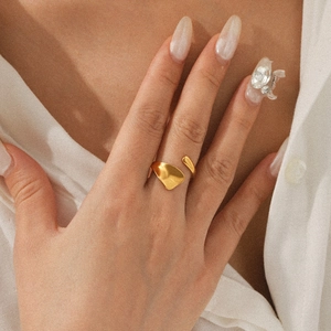 Close-up of minimalist 18K gold plated stainless steel open ring worn on a finger