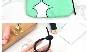 Macro view of a portable mint green fabric zipper pouch with textured silicone ring