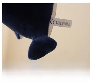 Macro detail of plush whale keychain showing tight stitching and CE certification tag