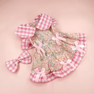 Detail of pink floral pet dress with plaid trim and matching bow for small dogs and cats