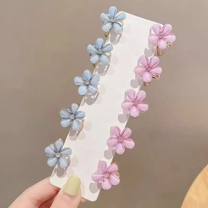 Set of 10 mini flower hair claws with blue and pink crystals on a display card