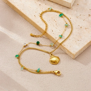 Gold double-layer starfish anklet with natural green stones and shell pendant on stone base