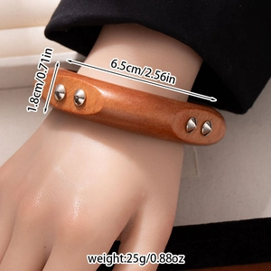 Detail view of wooden cuff bracelet with metal rivets showing 1.8cm width and 6.5cm diameter