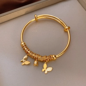Detail of gold-plated bracelet featuring lily of the valley and butterfly charms