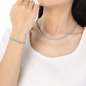 Silver evil eye jewelry set including necklace and bracelet with blue charms on model