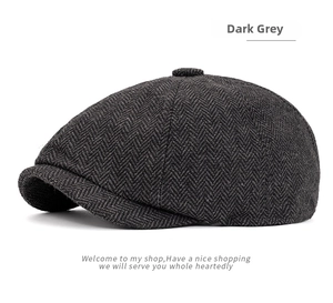 Detailed view of the dark grey herringbone tweed texture and brim on this newsboy cap