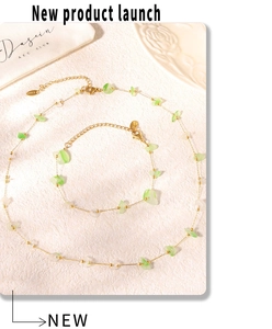 Detail of stainless steel necklace and bracelet set with green and white natural stones