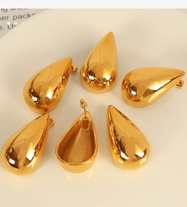 Detailed view of six gold teardrop earrings with high-polish mirror finish and smooth curves