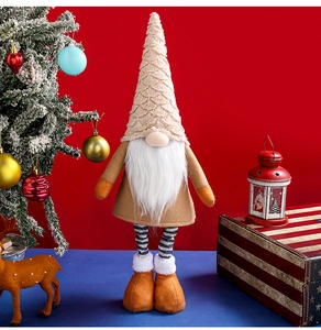 Detail of Christmas gnome plush with tall beige hat and long striped legs on festive decor