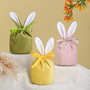Detailed view of pink, yellow, and green velvet bunny ear gift bags with ribbon bows