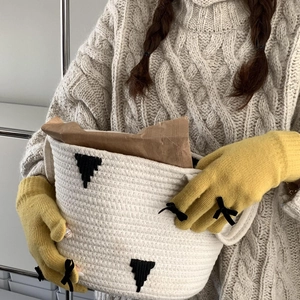 Close-up of yellow knit gloves with chic bow detail in a cozy home setting