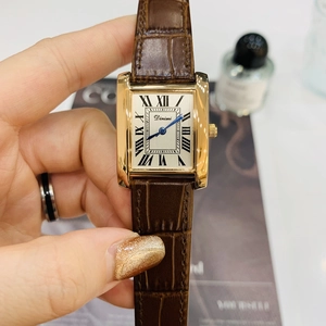 Rectangular gold watch with brown leather strap and Roman numerals on beige dial