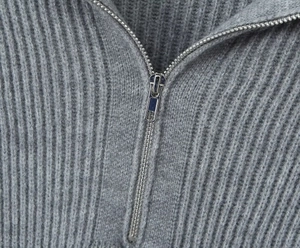 Detailed close-up of the metal zipper and ribbed knit collar on a grey sweater