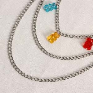 Close-up of multi-layer silver chain belt with blue, yellow and red gummy bear charms