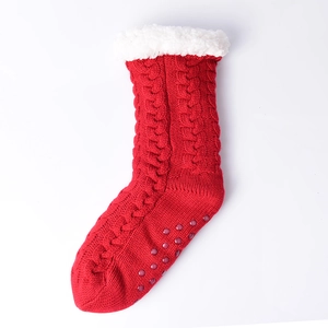 Detailed view of red knitted slipper socks with plush white cuff and anti-slip dots on sole