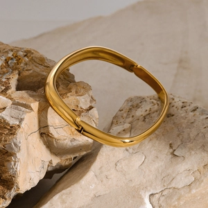 Dettaglio del bracciale quadrato dorato su pietra naturale con finitura lucida