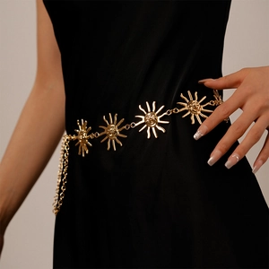 Close-up of a gold vintage sun face pendant on a geometric metal waist chain belt