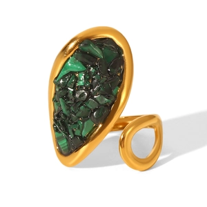 Detailed macro of vintage gold ring featuring an irregular green stone centerpiece