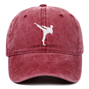Detailed view of red washed cotton baseball cap with white kung fu silhouette embroidery