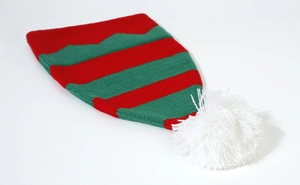Detailed close-up of knitted Christmas hat with red and green stripes and white pom-pom