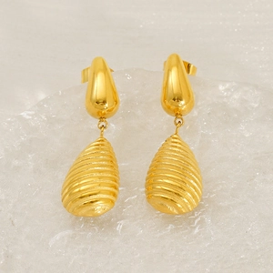 Détail de boucles d'oreilles goutte dorées avec texture spirale et fini or 18K