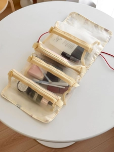 Foldable beige travel makeup organizer with four individual mesh zipper storage compartments