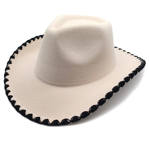 Détail d'un chapeau de cowboy en feutre beige avec bordure brodée ondulée noire