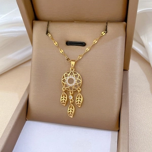 Macro shot of a luxury gold dreamcatcher necklace with sparkling zircon and leaf charms