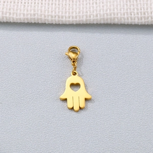 Pendentif Main de Fatima doré avec cœur ajouré et fermoir mousqueton sur fond gris