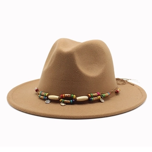 Détail d'un chapeau en laine marron avec ruban perlé bohème et breloques en métal