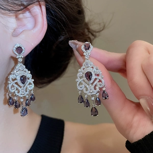 Detailed close-up of vintage palace style silver earrings with purple teardrop zircon tassels