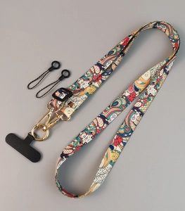 Detail view of patterned fabric phone lanyard with golden swivel hook and black adjuster