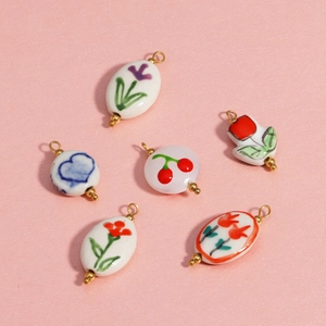 Ceramic flower and heart pendants with 18K gold-plated rings on pink background