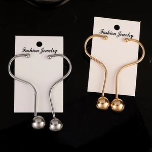 Boucles d'oreilles minimalistes incurvées en or et argent sur carte