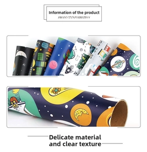 Close-up of thick space-themed wrapping paper roll showing detailed planet patterns