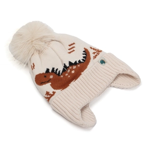 Detail einer Kinder-Strickmütze mit Dino-Jacquard und flauschigem Bommel-Akzent