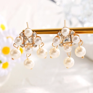 Detailed close-up of French vintage gold pearl earrings with square crystal and fringe