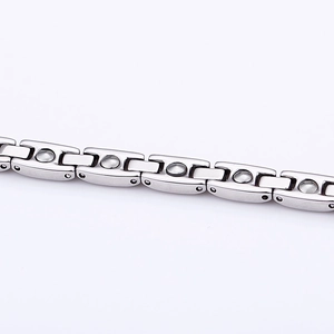 Macro shot of silver titanium steel therapeutic bracelet with H-link and magnetic inserts