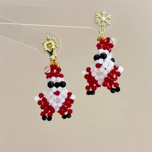 Detail view of handmade beaded Santa Claus earrings with golden snowflake hooks