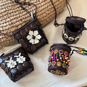 Detail of four handmade bohemian woven bags with shell beads and floral accents
