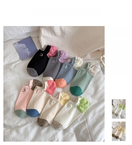 Close-up of colorful dopamine style socks with minimalist white smile embroidery