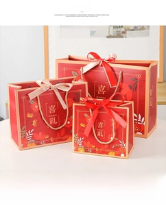 Close-up of red Chinese gift bags with gold characters and decorative silk bows